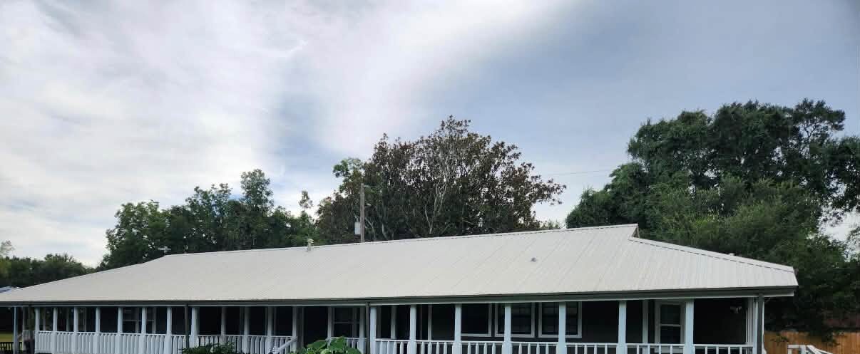 The same ranch house after washing, the porch rails crisp white the whole length